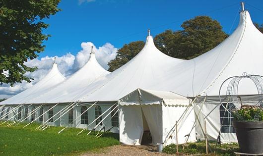 tall green portable restrooms assembled at a music festival, contributing to an organized and sanitary environment for guests in Birmingham